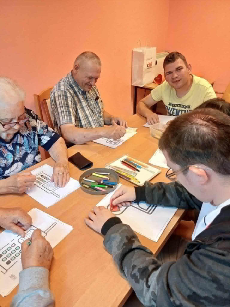 Podopieczni przygotowują plakat informacyjny