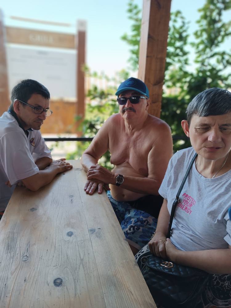 Podopieczni siedzą pod wiatą wypoczynkową