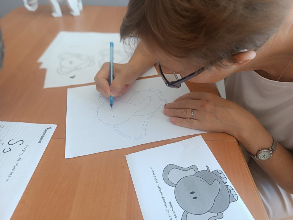 Podopieczni wykonują prace plastyczne dotyczące słoni