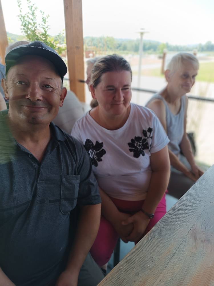 Podopieczni siedzą pod wiatą wypoczynkową