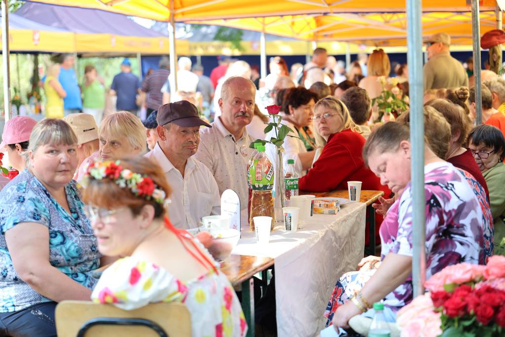 uczestnicy imprezy siedzą w namiotach piknikowych