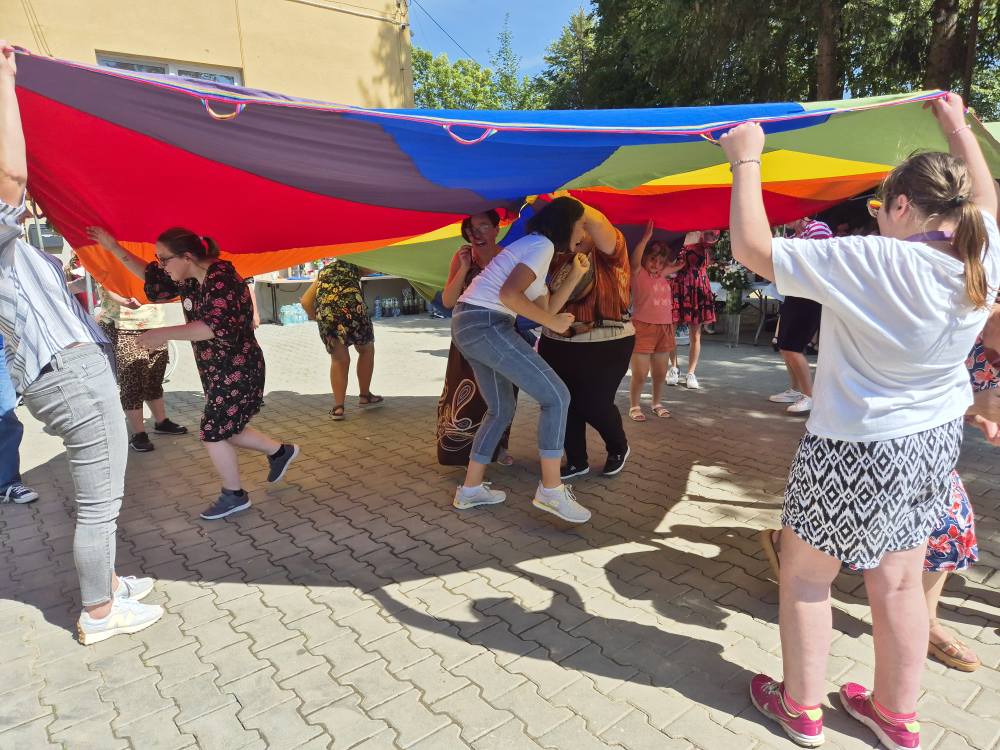 uczestnicy pikniku biorą udział w animacjach z chustą
