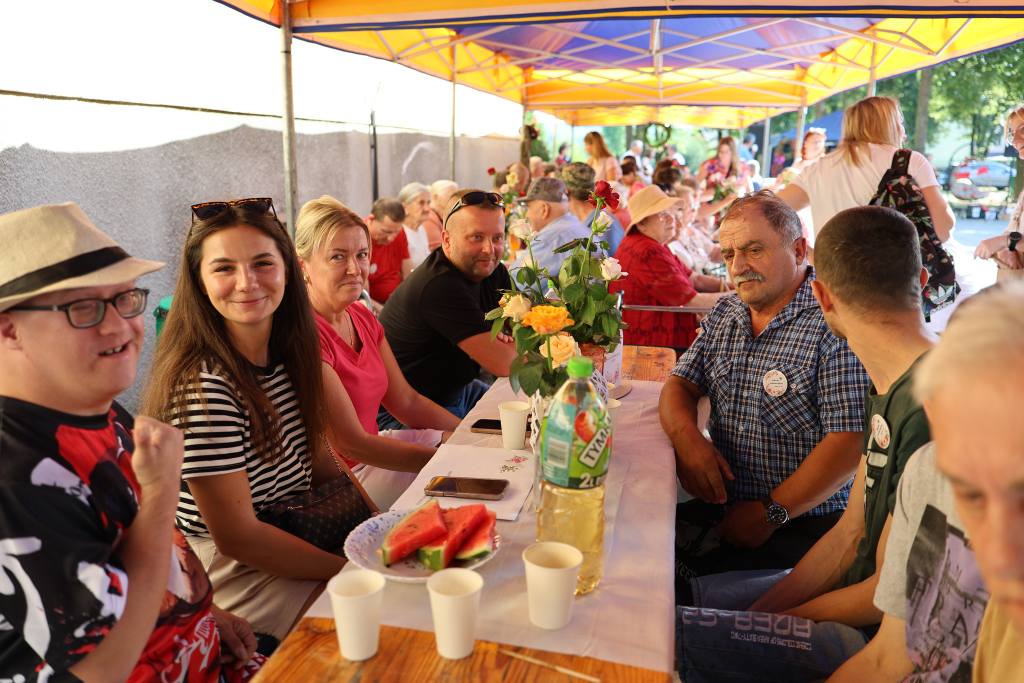 uczestnicy imprezy siedzą w namiotach piknikowych