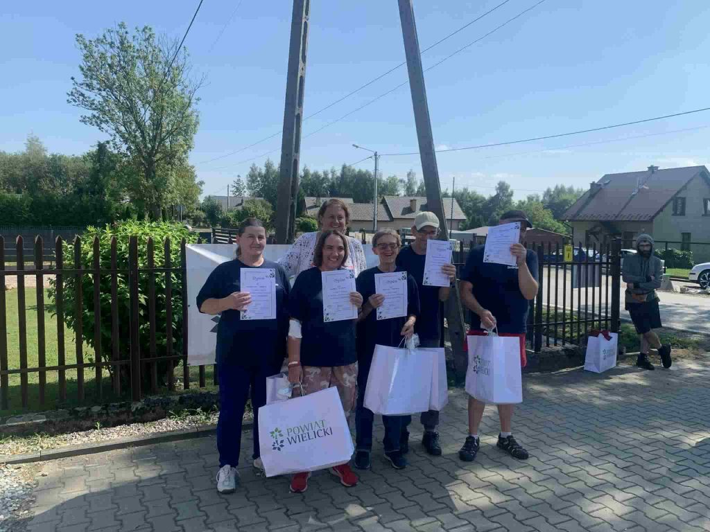 Grupa podopiecznych pozuje do zdjęcia z nagrodami i dyplomami