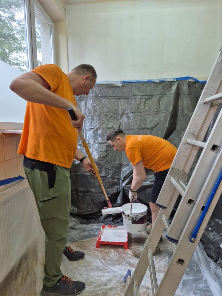 Wolontariusze z ING malują pomieszczenie w ŚDS