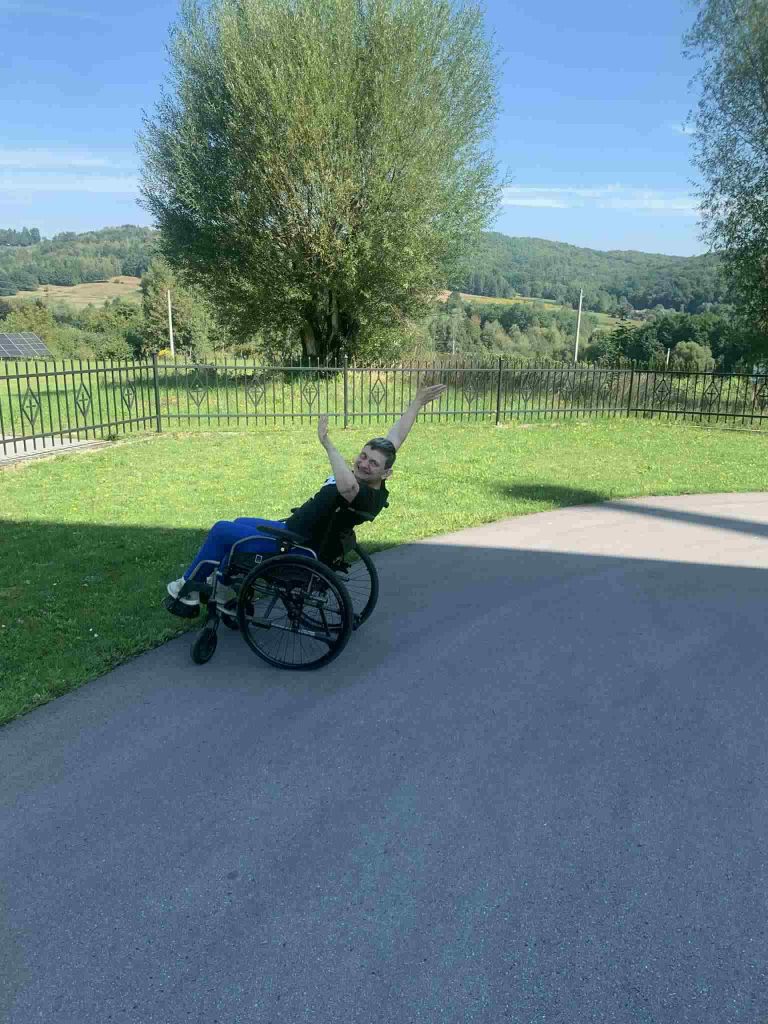 Podopieczna na wózku ćwiczy na świeżym powietrzu