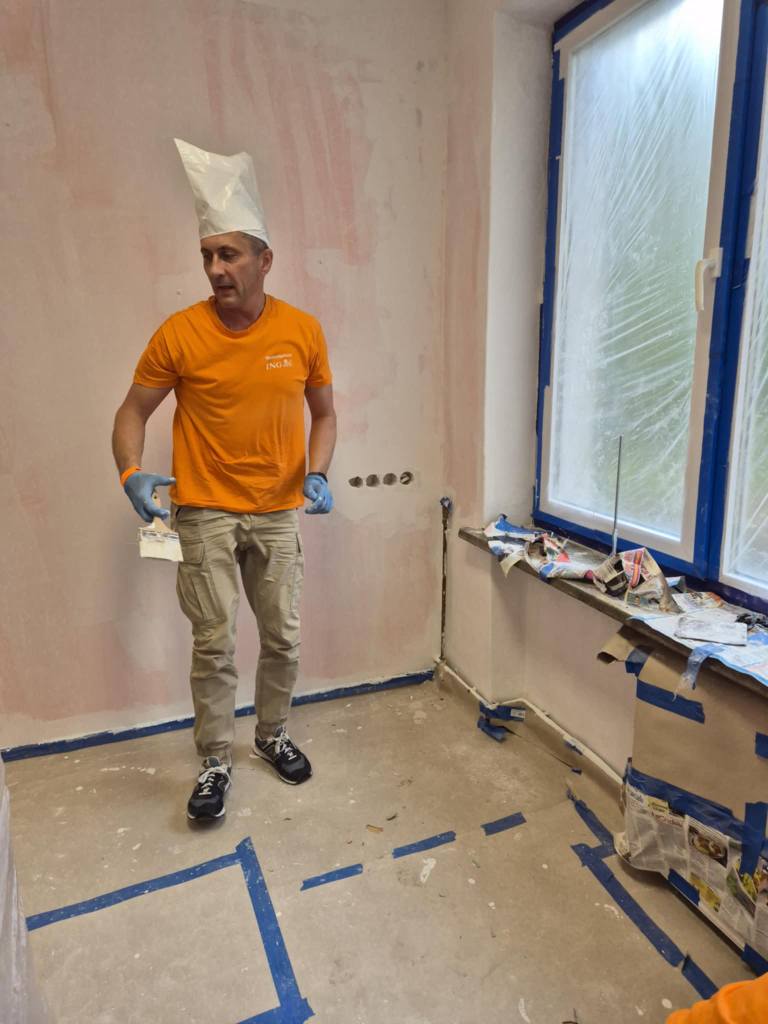 Wolontariusz ING maluje pomieszczenie w ŚDS