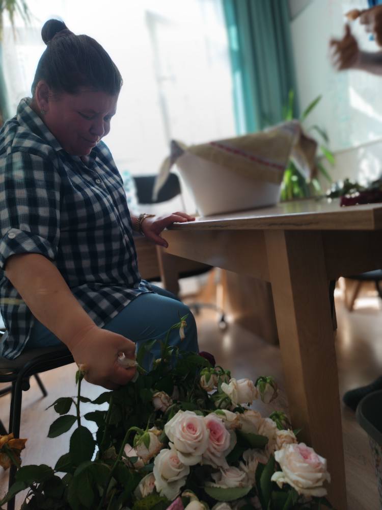Podopieczna przygotowuje płatki róż do suszenia