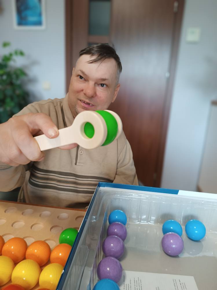 Podopieczny układa kolorowe kule