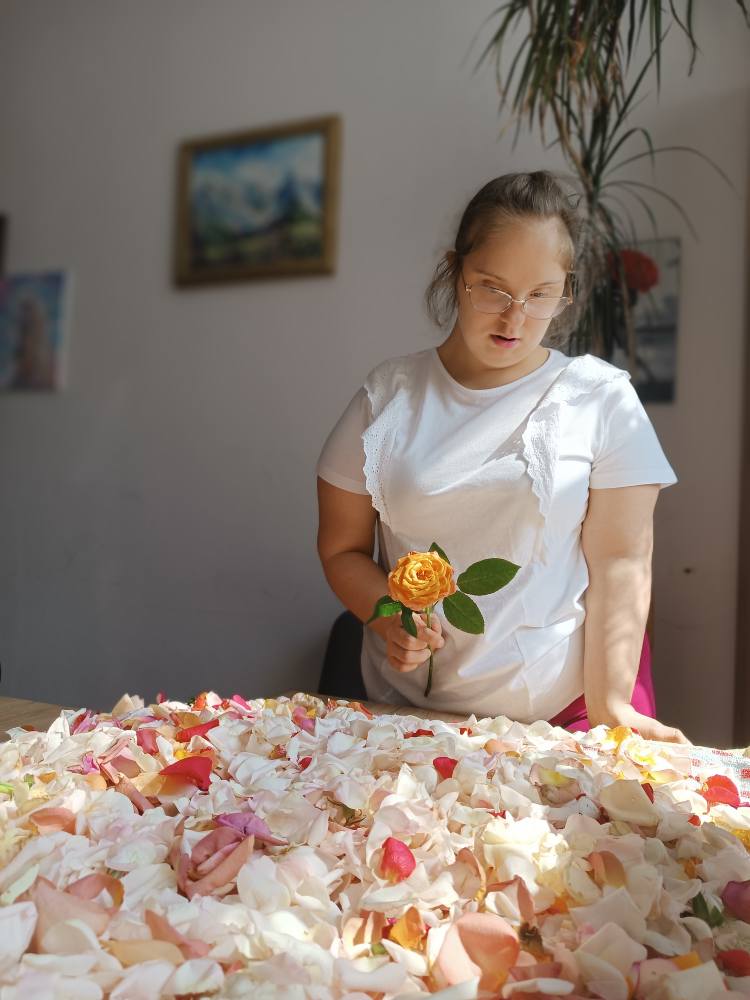 Podopieczna pozuje z kwiatem róży