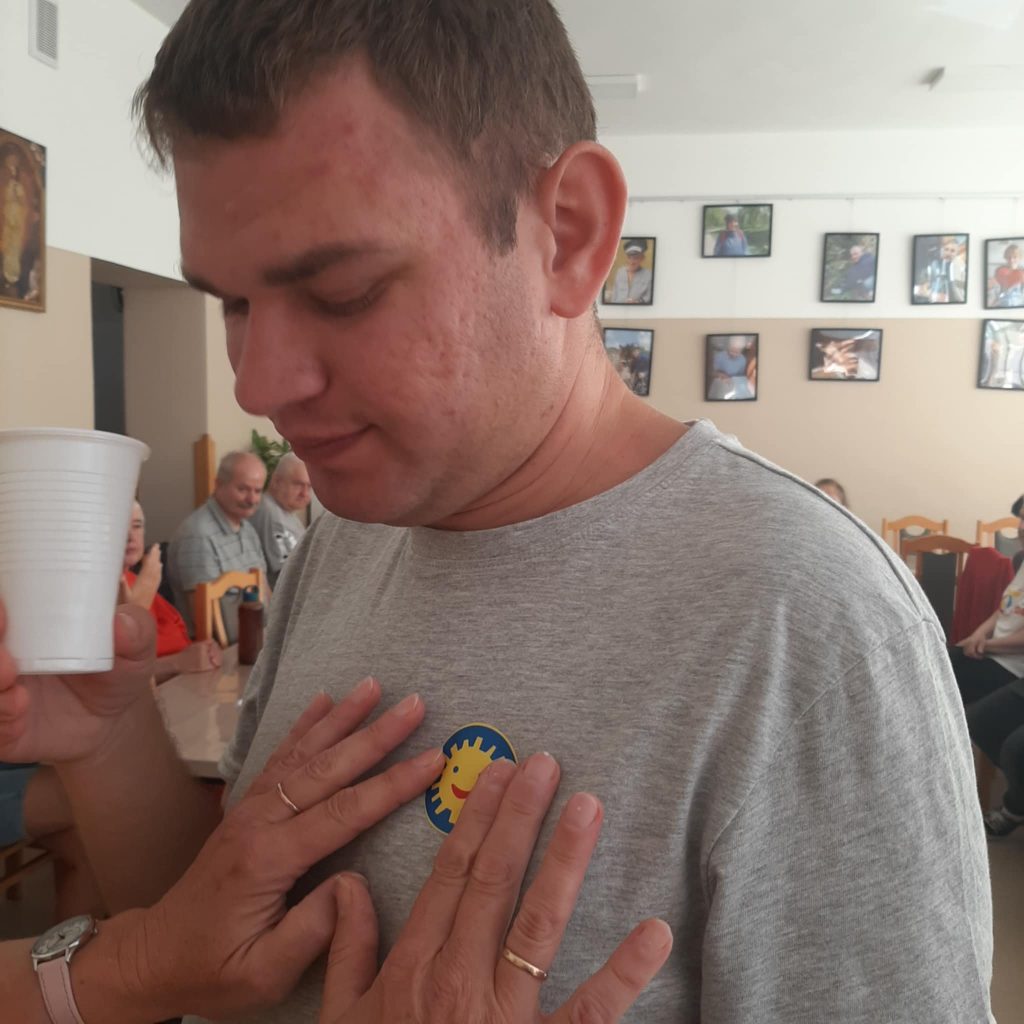 Pani Monika dekoruje podopiecznych naklejkami z orderem uśmiechu