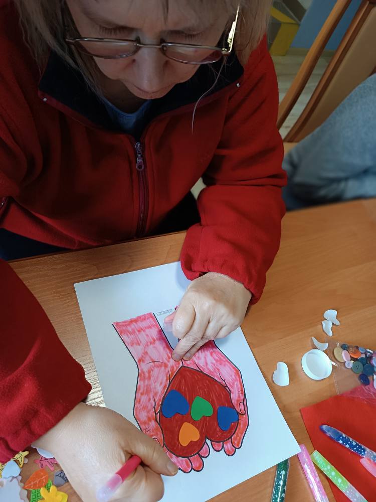 Podopieczna wykonuje pracę plastyczną