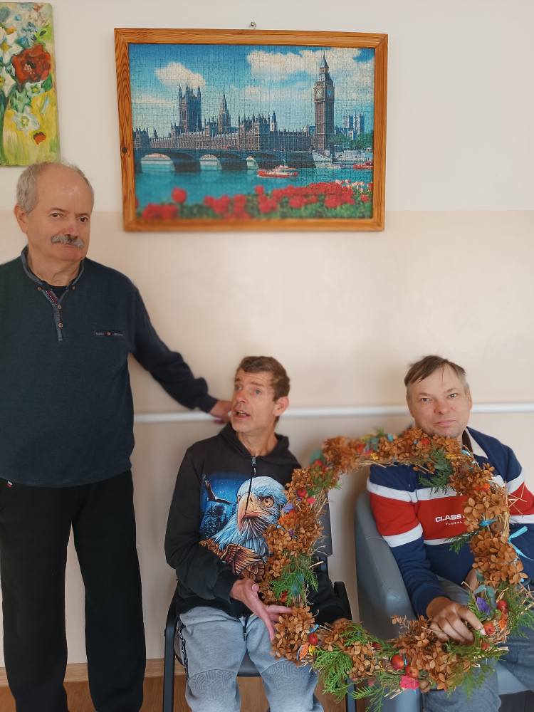 Podopieczni trzymają wieniec wykonany na zajęciach