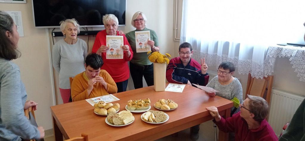 Grupa Podopiecznych wraz terapeutą prezentuje dyplomy i przygotowane wypieki