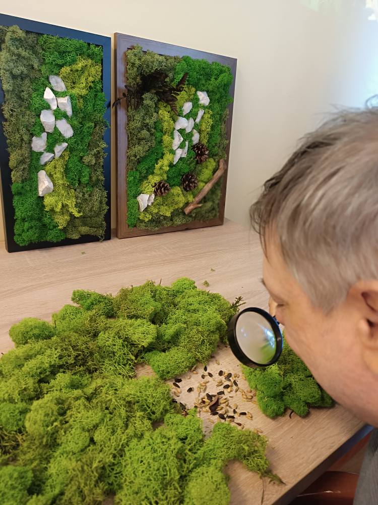 Podopieczny ogląda mech przez lupę
