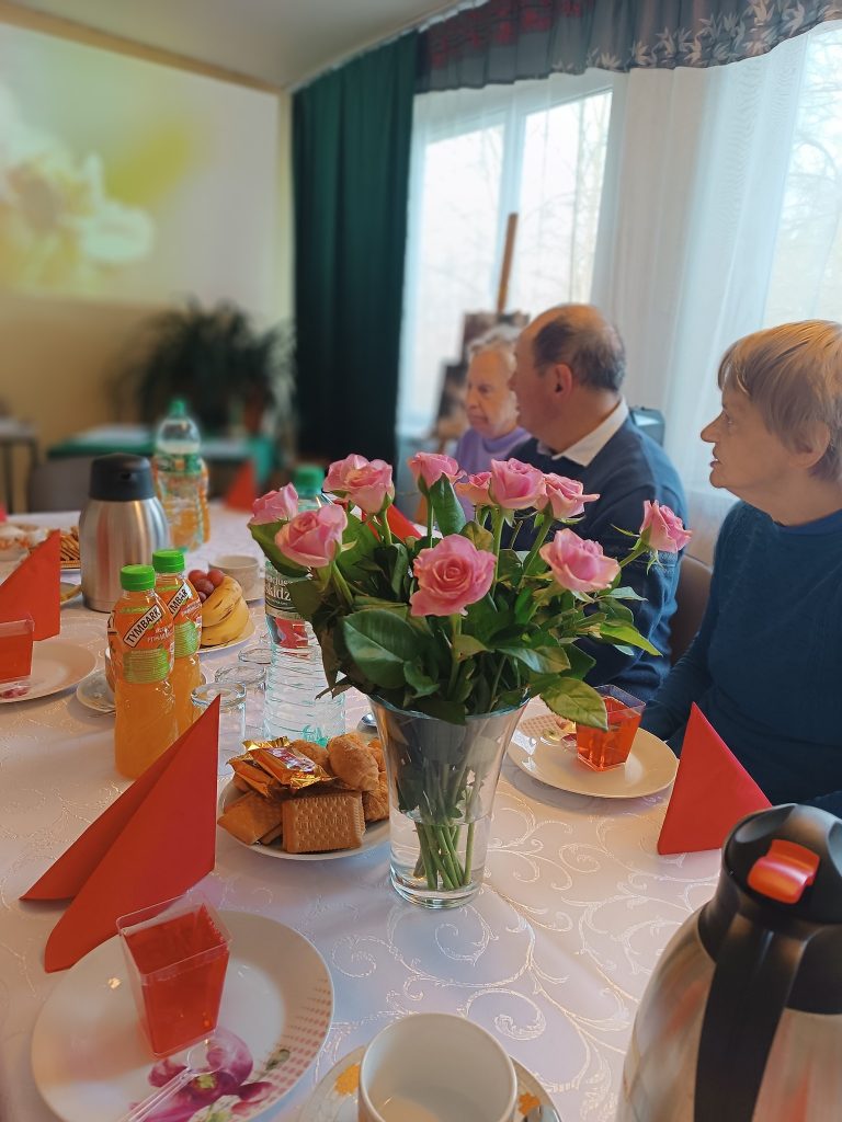 uczestnicy spotkania z okazji Dnia Seniora oglądają filmik tematyczny