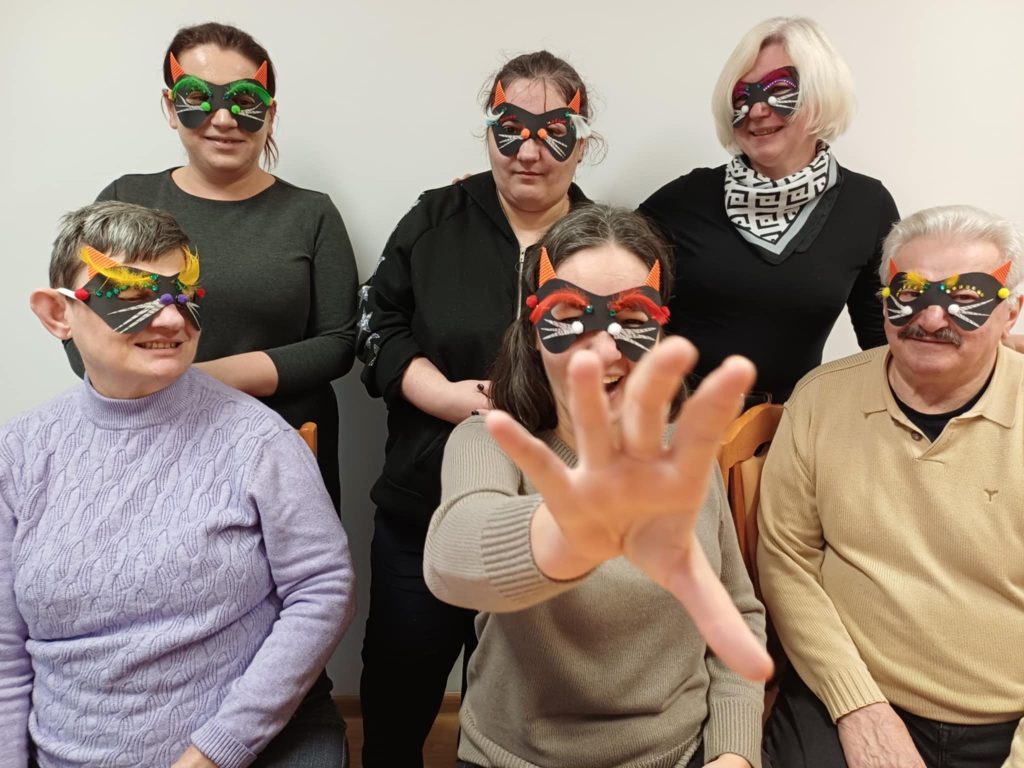 uczestnicy pozują do zdjęcia w maskach wykonanych podczas zajęć tematycznych