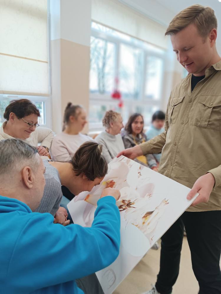 podopieczni oglądają tablicę informacyjną poświęconą modliszkom