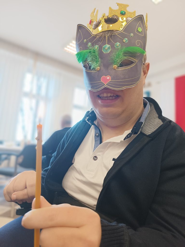 Podopieczny pozuje do zdjęcia w masce andrzejkowej