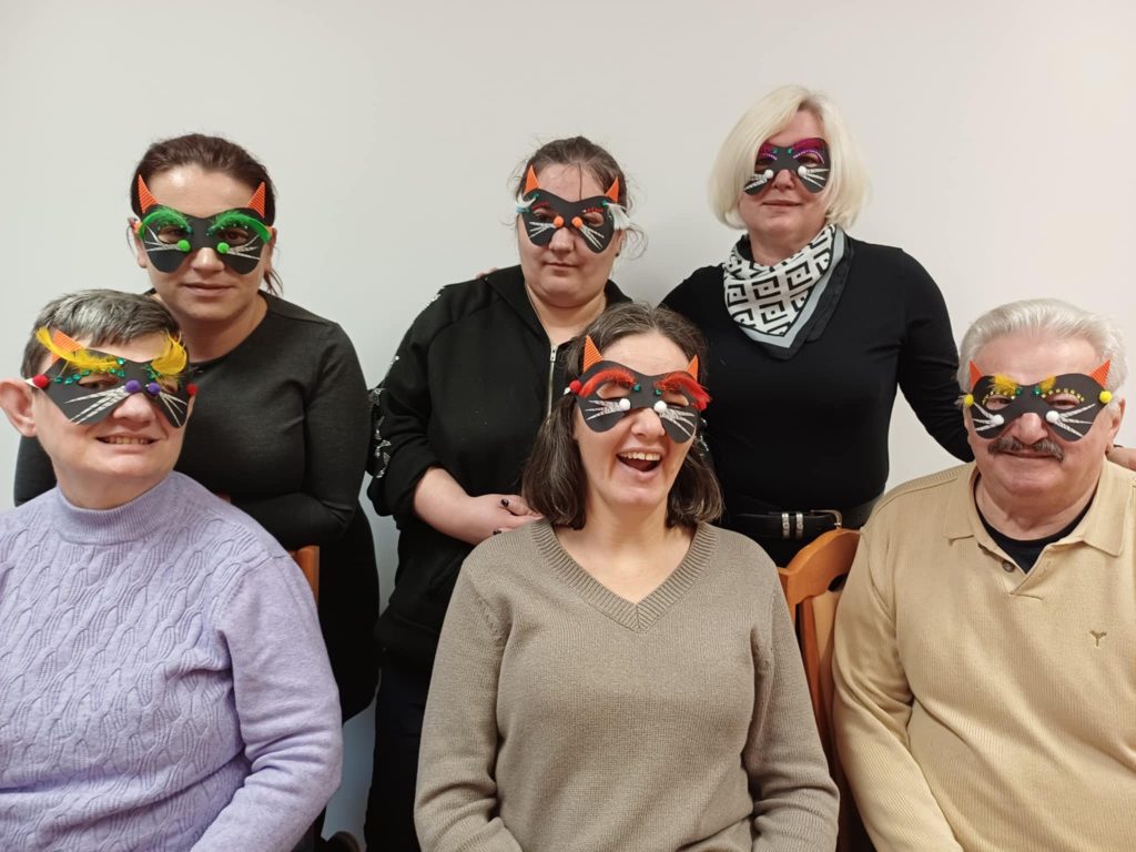 uczestnicy pozują do zdjęcia w maskach wykonanych podczas zajęć tematycznych