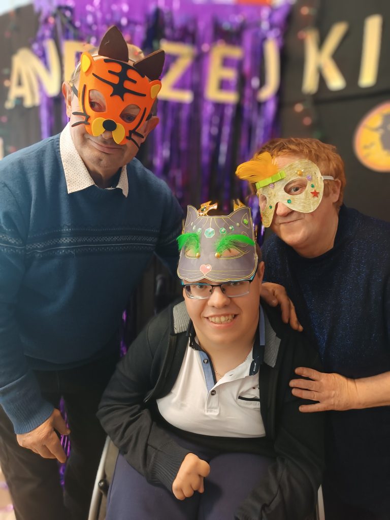 Podopieczni pozują do zdjęcia w maskach andrzejkowych