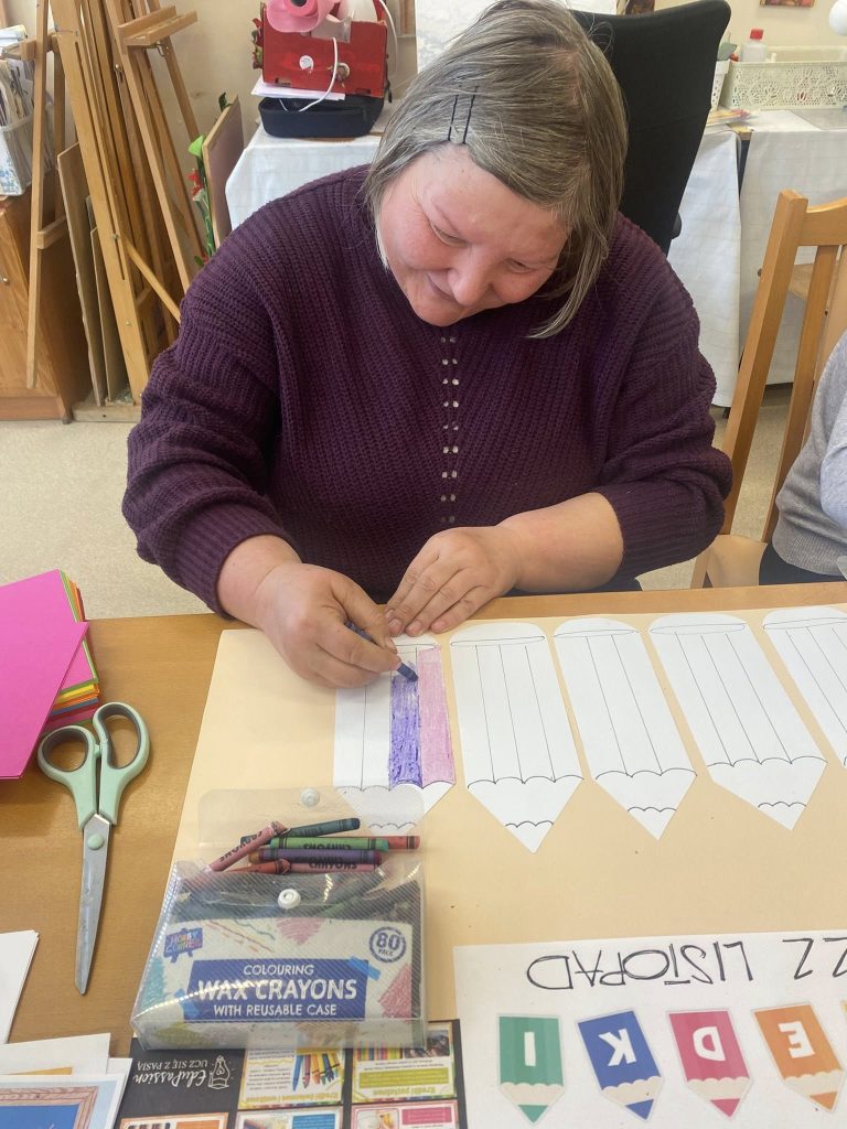 Podopieczna koloruje kredkami