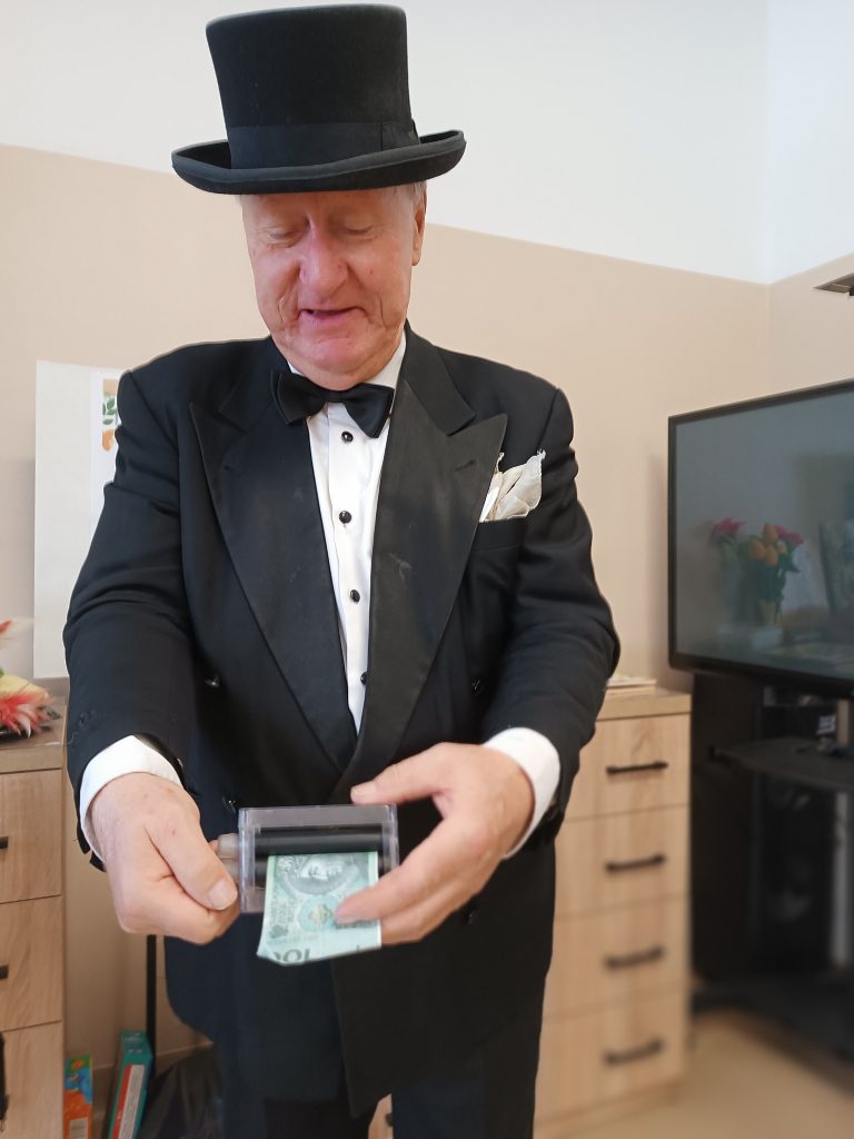 iluzjonista wykonuje sztuczkę magiczną