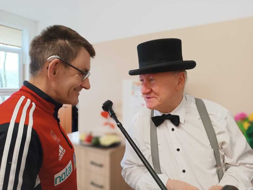 Iluzjonista wykonuje sztuczkę przy udziale podopiecznego