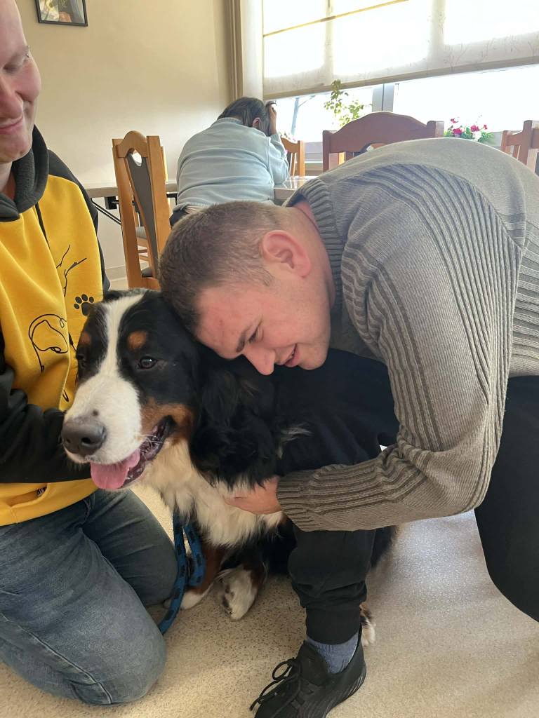 Podopieczny przytula psa podczas zajęć dogoterapii