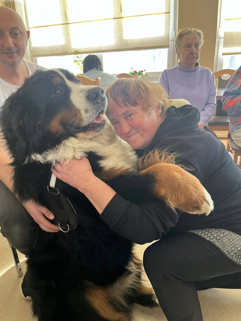 Podopieczna przytula psa podczas zajęć dogoterapii