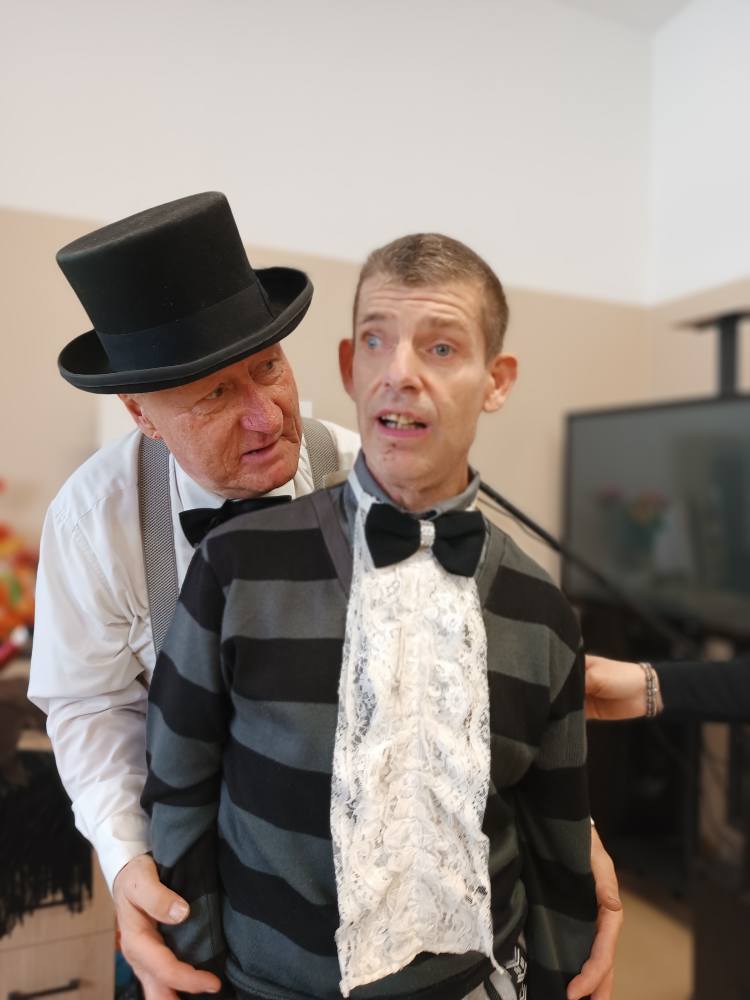 Iluzjonista wykonuje sztuczkę przy udziale podopiecznego