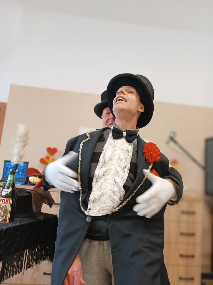 Iluzjonista wykonuje sztuczkę przy udziale podopiecznego