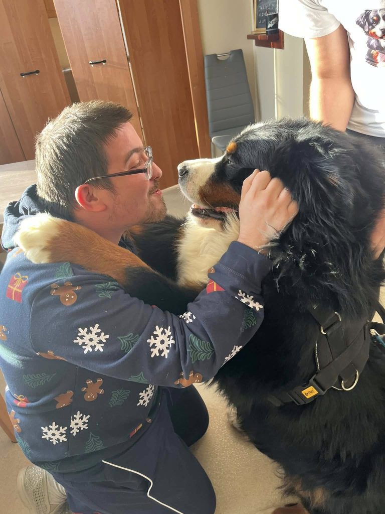 Podopieczny przytula psa podczas zajęć dogoterapii