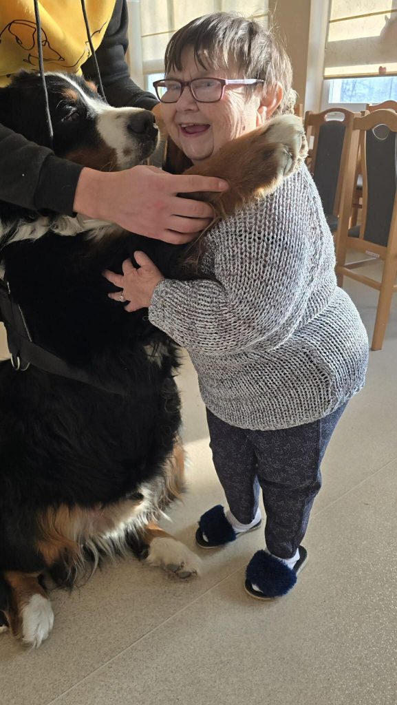 Podopieczna przytula psa podczas zajęć dogoterapii