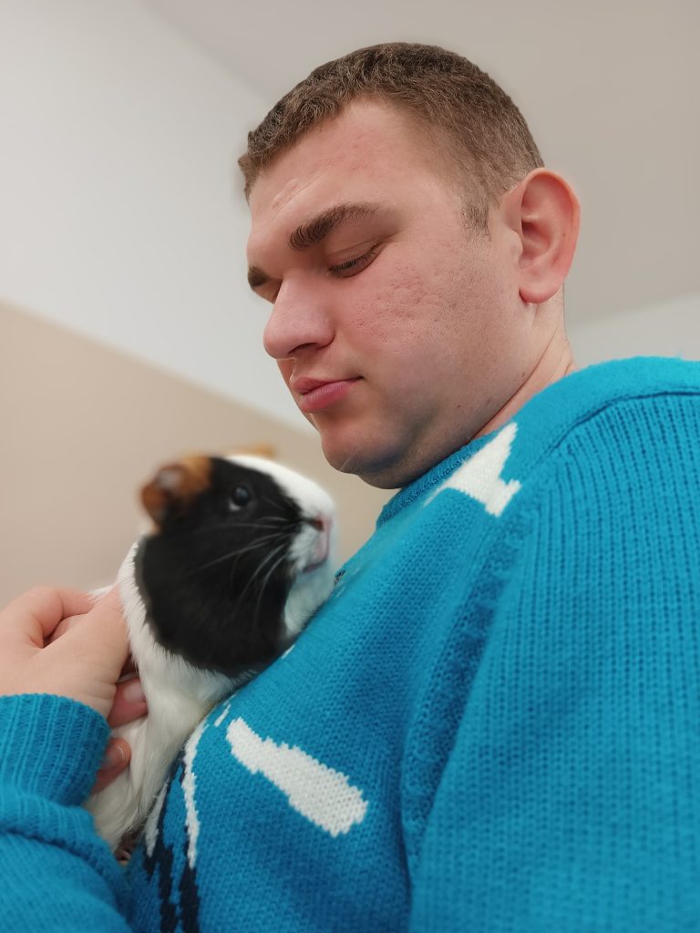 Podopieczny trzyma w rękach świnkę morską