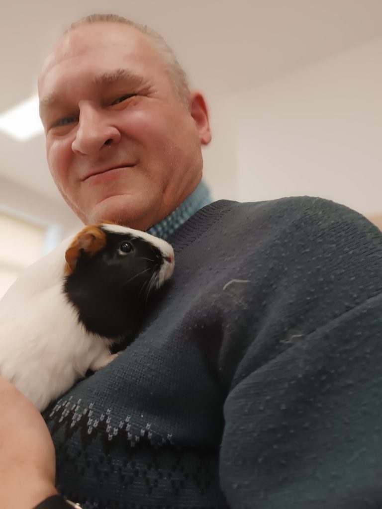 Podopieczny trzyma świnkę morską