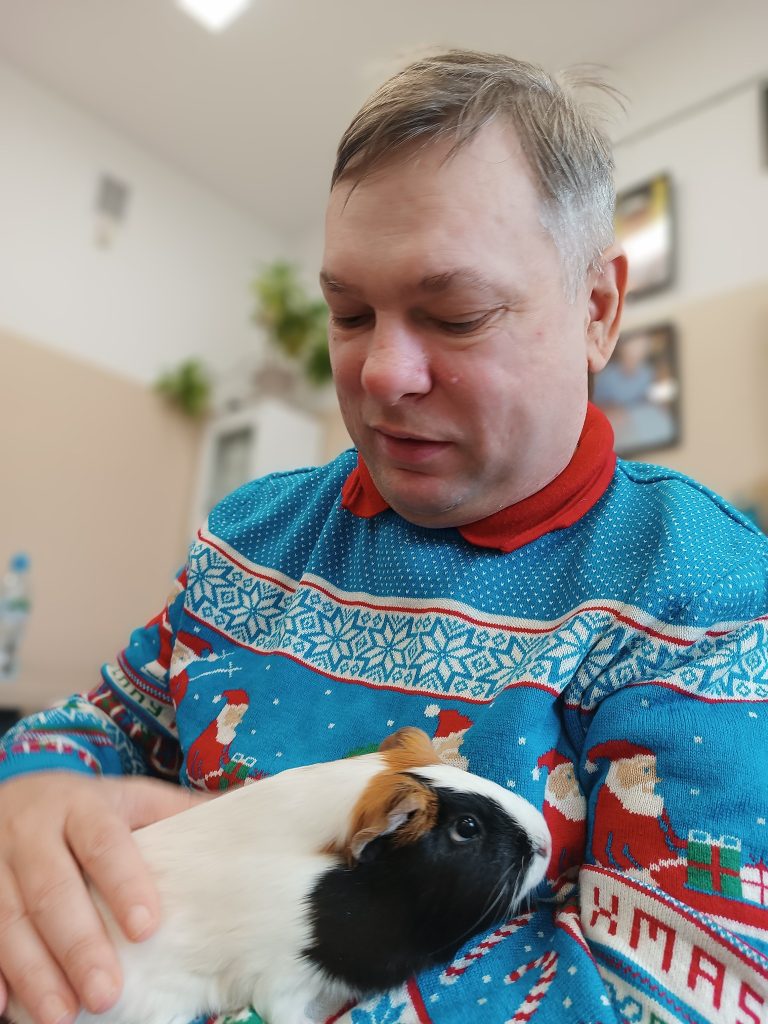 Podopieczny trzyma w rękach świnkę morską