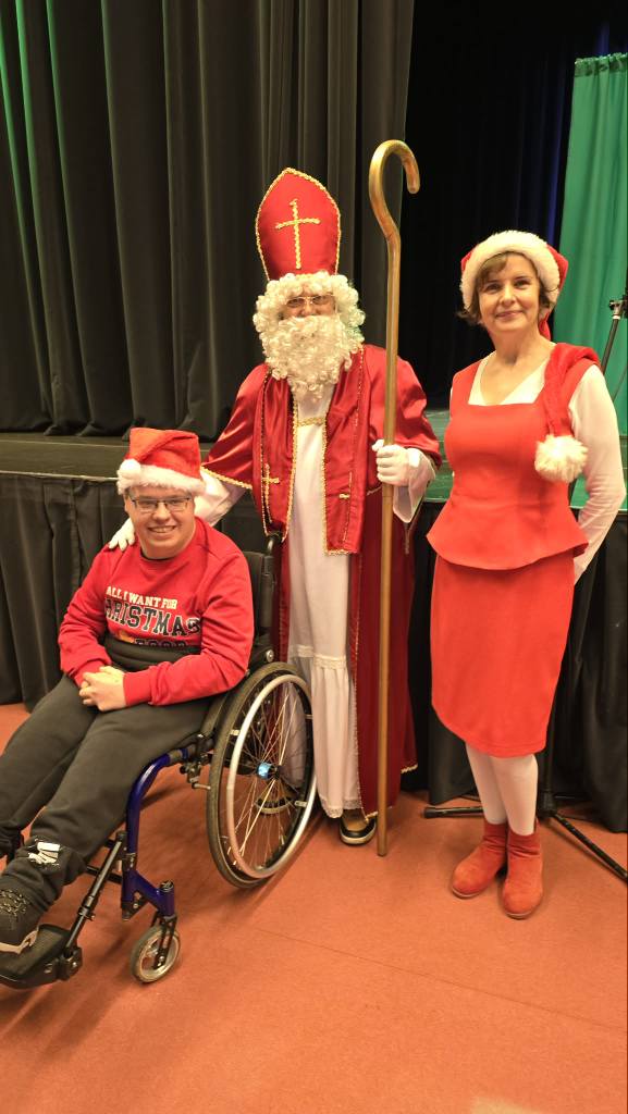 Podopieczny pozuje do zdjęcia z Mikołajem i Mikołajową