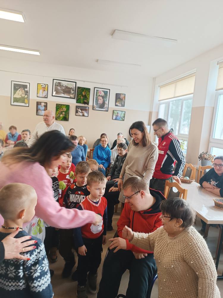 Przedszkolaki rozdają pierniczki podopiecznym