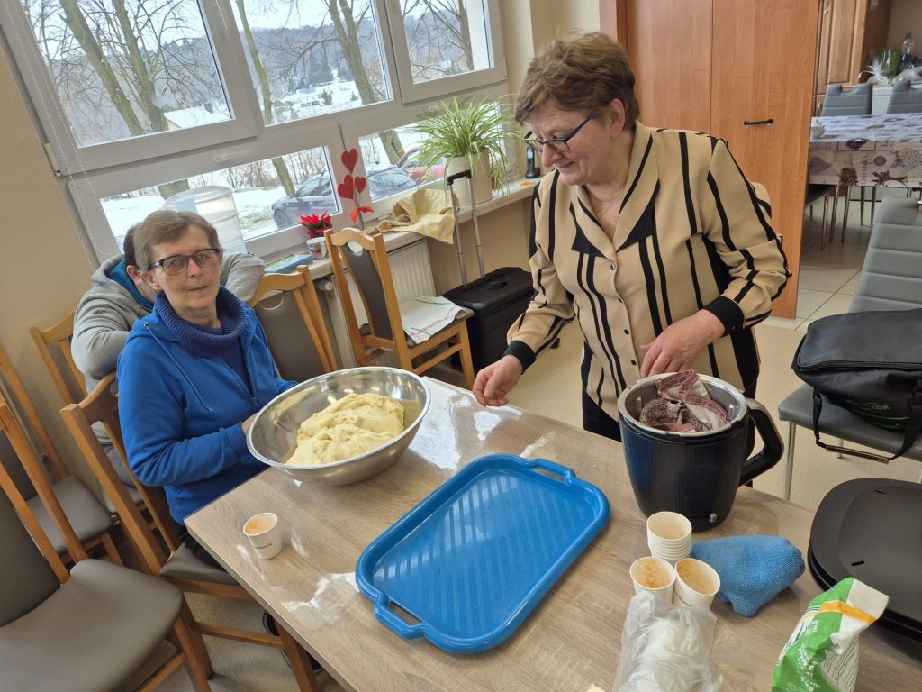 podopieczni z prowadzącymi przygotowują ciasto na bułeczki