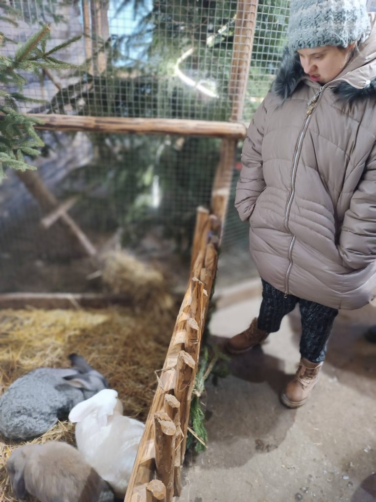 Podopieczna ogląda króliki w szopce