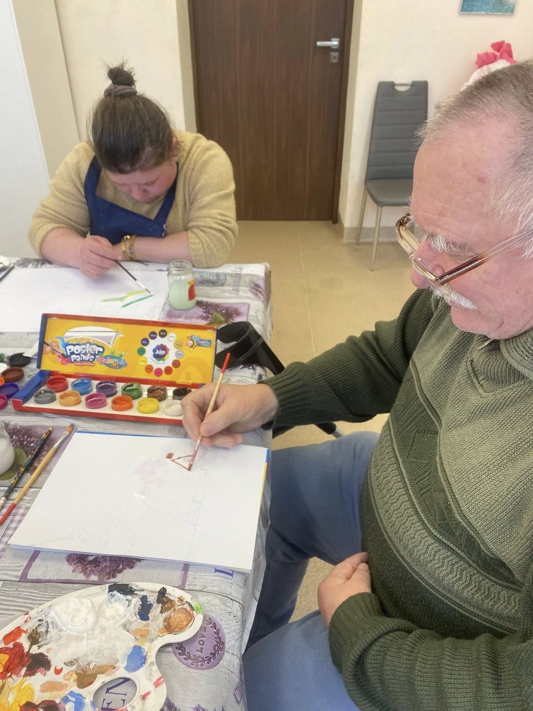 podopieczni malują farbami pracę plastyczną