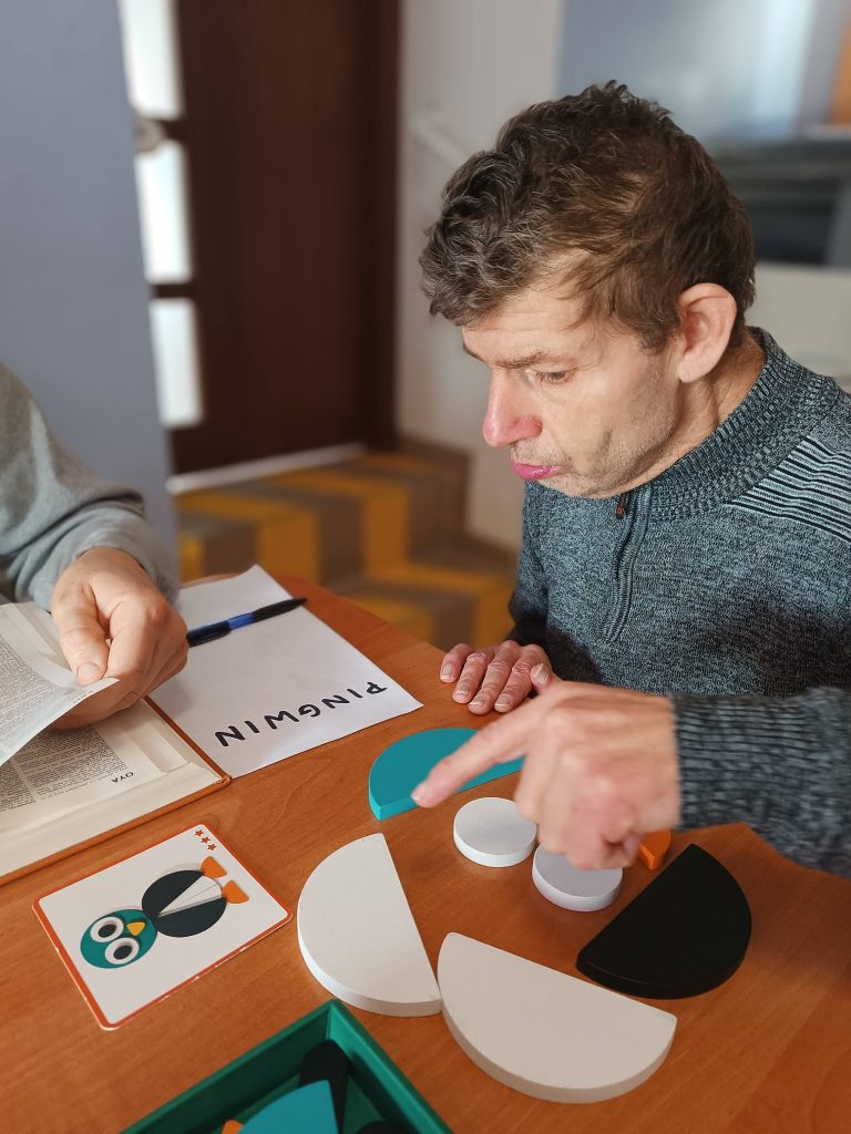 Podopieczny układa klocki drewniane