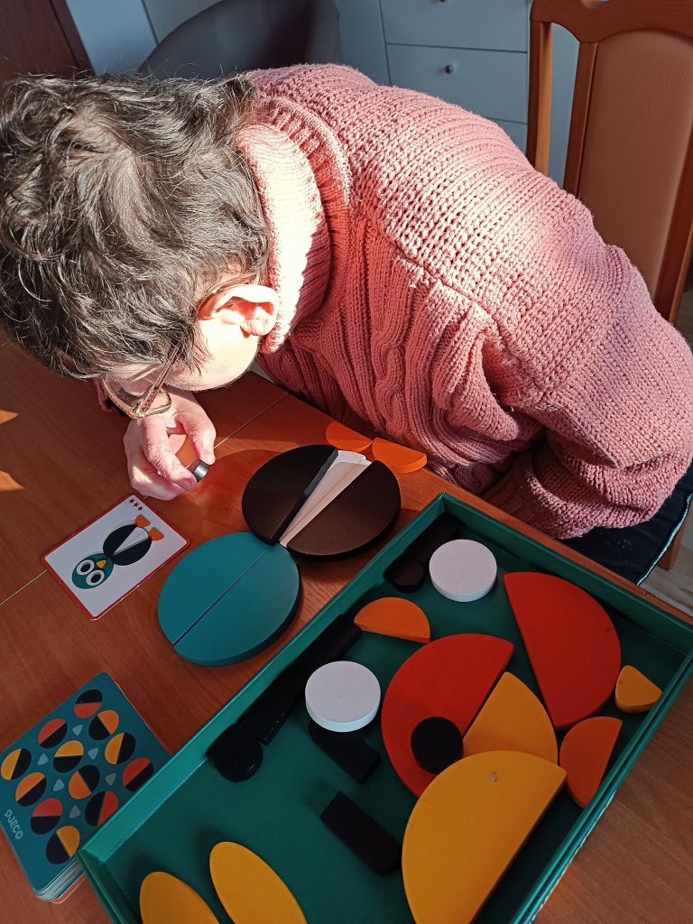 Podopieczna układa klocki drewniane