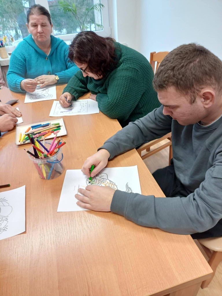 Podopieczni kolorują kredkami obrazki związane z tematem spotkania