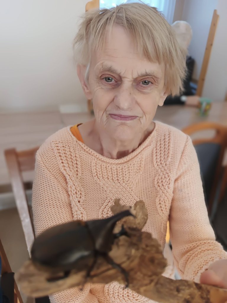 Podopieczna trzyma gałązkę na której siedzi chrząszcz