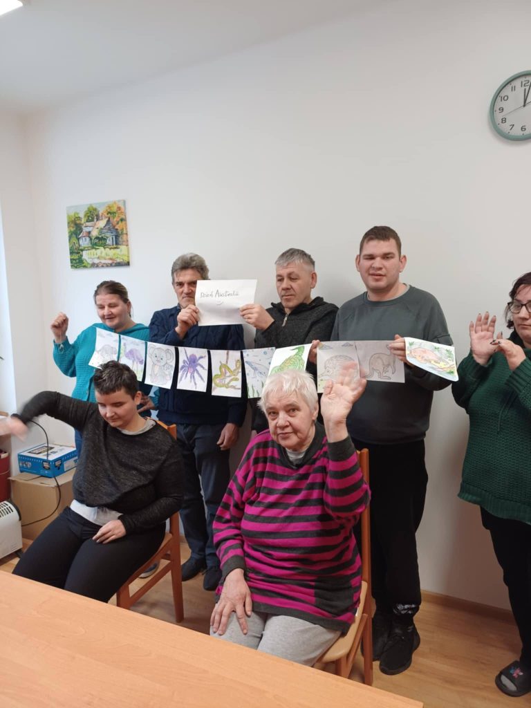 grupa osób prezentuje prace wykonane podczas zajęć o Australii