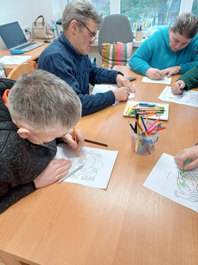 Podopieczni kolorują kredkami obrazki związane z tematem spotkania