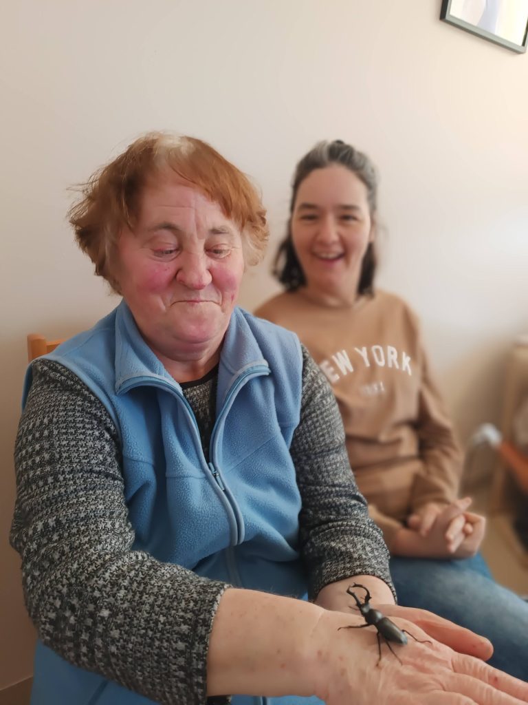 Podopieczna trzyma chrząszcza na dłoni