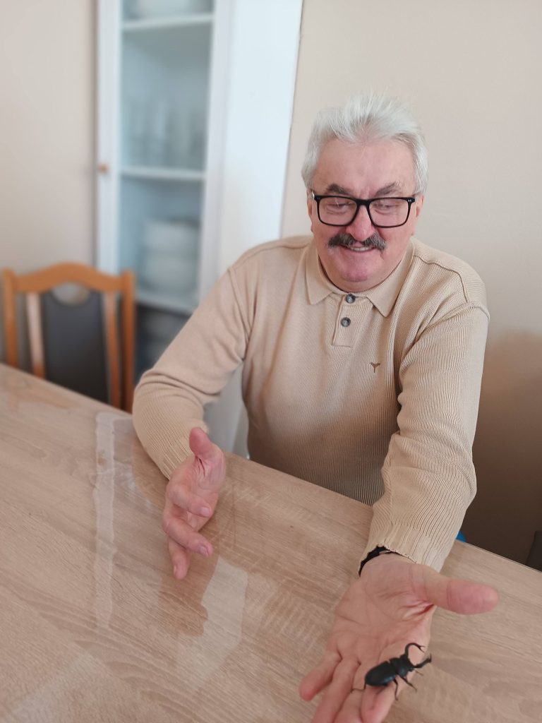 Podopieczny trzyma chrząszcza na dłoni